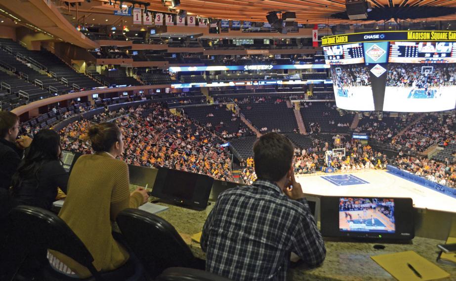 Students behind the broadcast board at a sports game