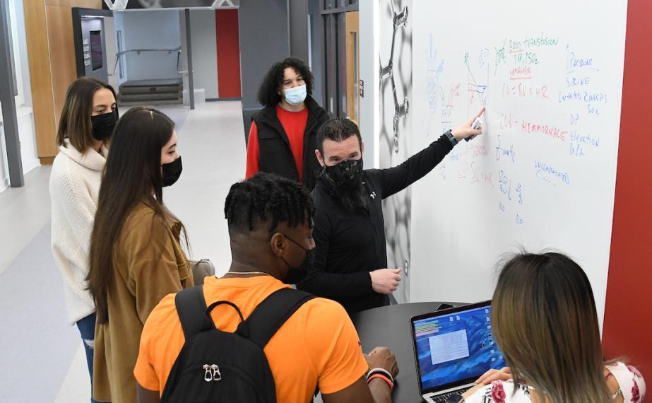 Students in masks learn exercise science in Hennessy Science and Technology Center