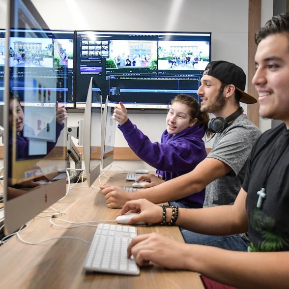 Three students in a computer lab working together