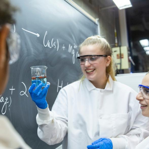 Female student holds up beaker 