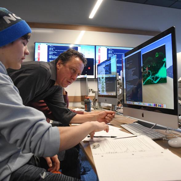 Faculty and student in the media lab discussing a design on the computer