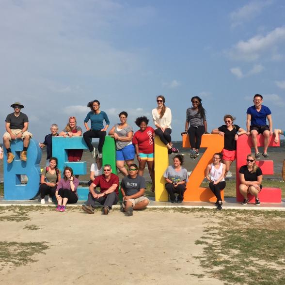 Group of GEMS students posing on the Belize sign 