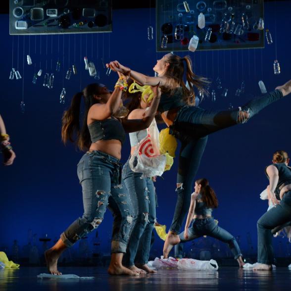 Female student dancers in action on a stage with recycled materials