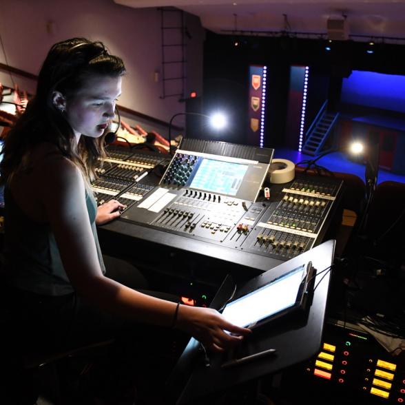 Student works on lighting board for show