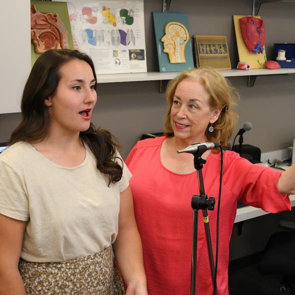 Faculty member works with student in voice lab