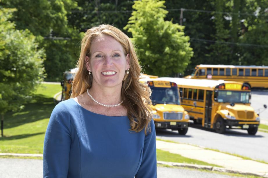 Kari McGann, Class of 2020 in front of school busses