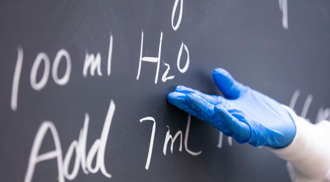 Person pointing to a chalkboard