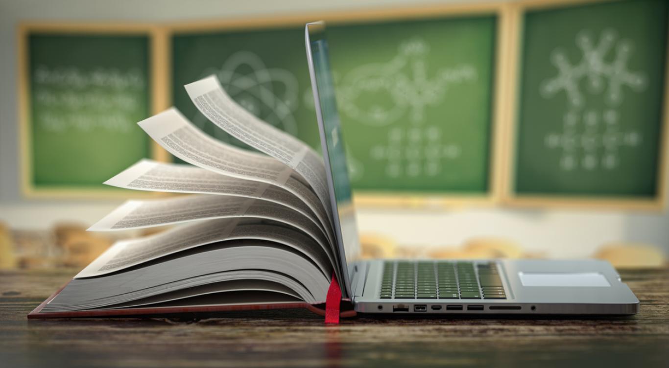 Book mingled with laptop in classroom