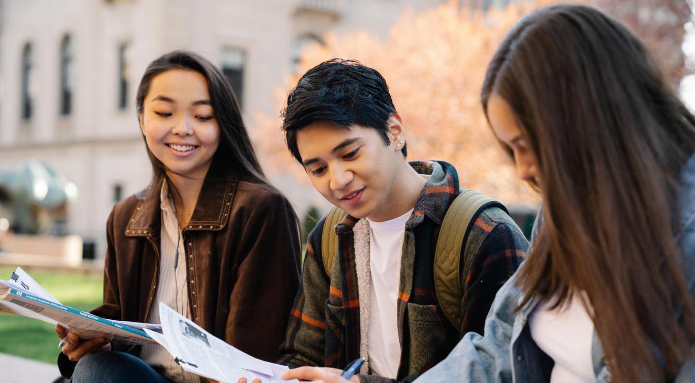 Students looking at papers outside