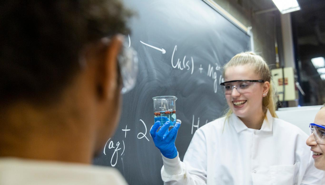 Female student holds up beaker