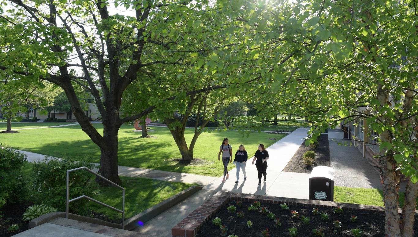 Students walk across campus in spring