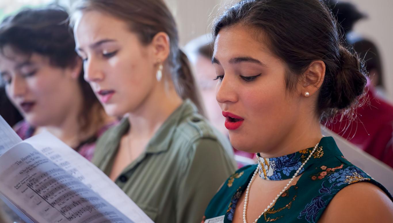 Female singers singing from a song book