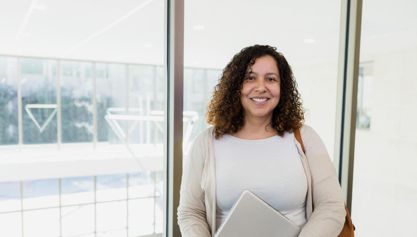 Woman holding computer smiles