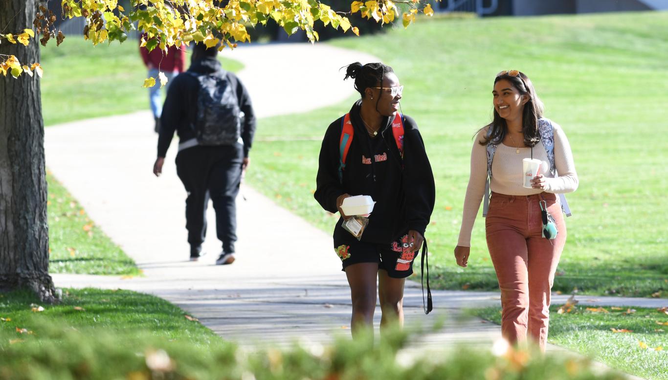 students smiling and walking on campus