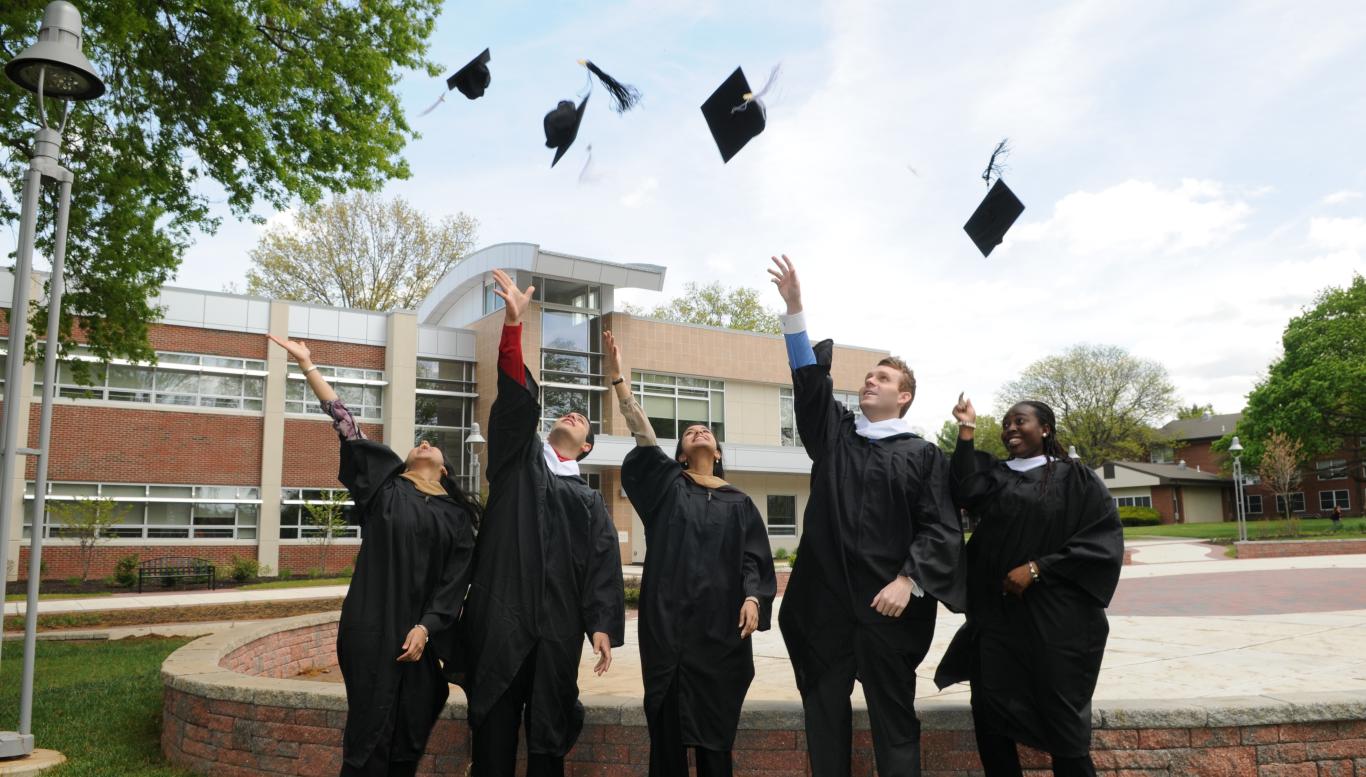 Students throwing caps in air at commencement on Rider campus