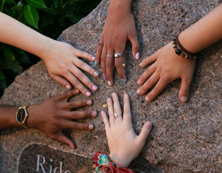 A variety of students' hands on the Rider Rock