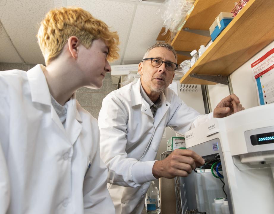 Student working with professor in science lab