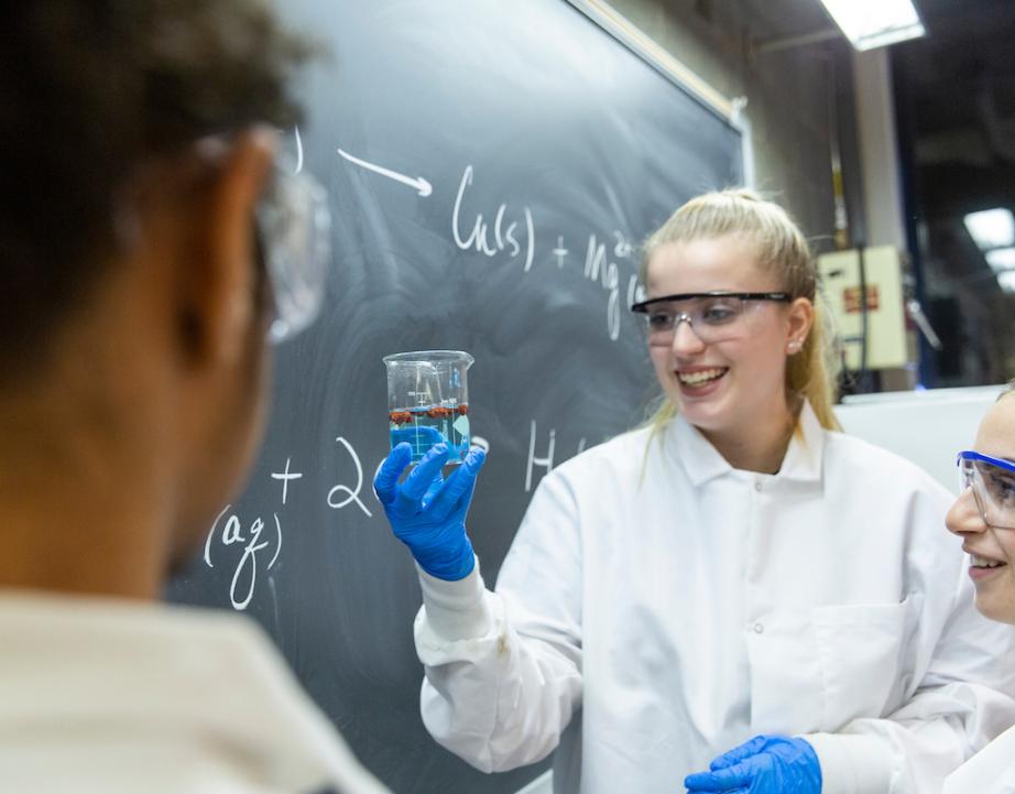 Female student holds up beaker 