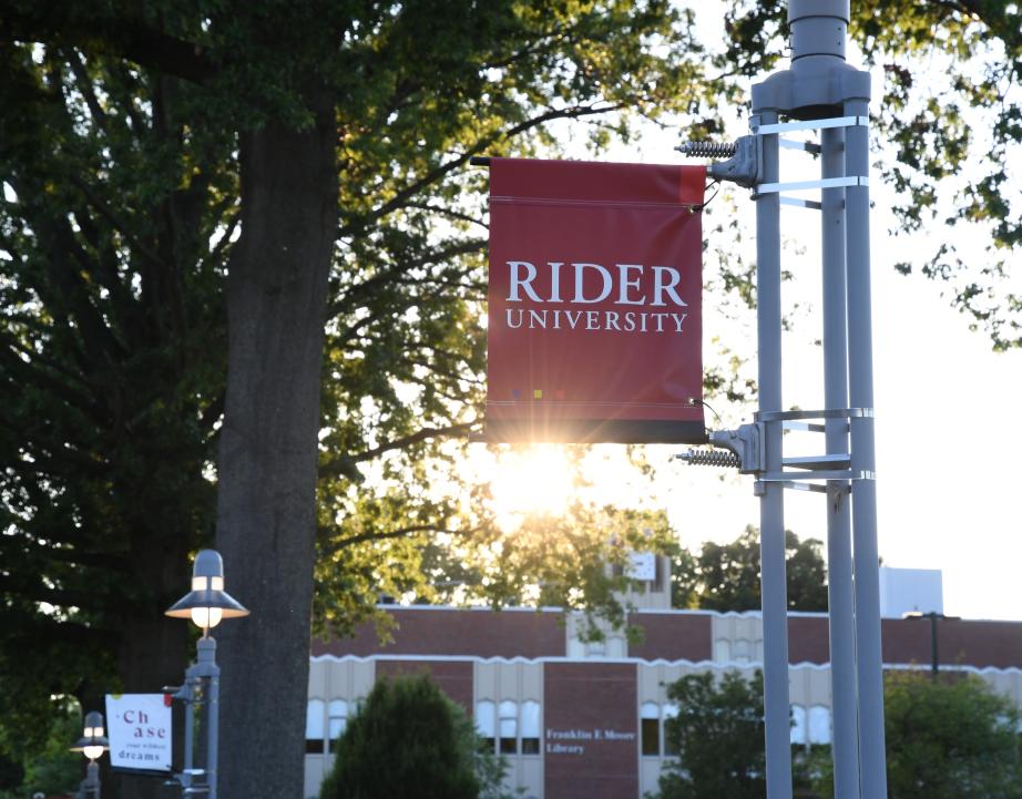Rider sign at sunset in front of Moore library
