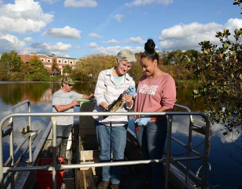 Student and faculty on a boat on Centennial Lake doing research