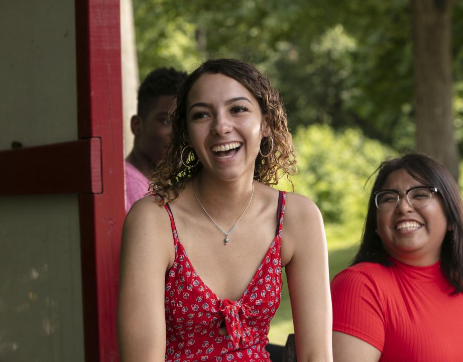 Students laugh while sitting outside