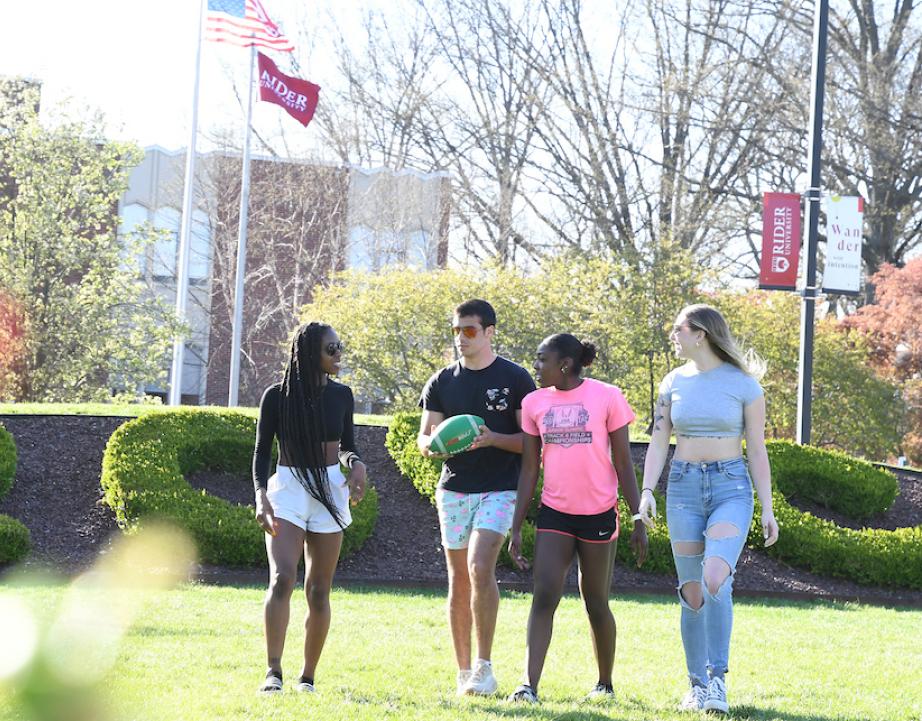 Four students walk across the campus mall