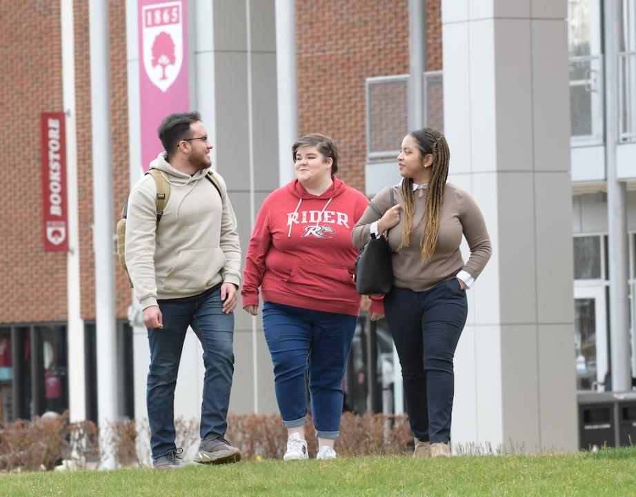 Three students walk near the Bart Luedeke Center