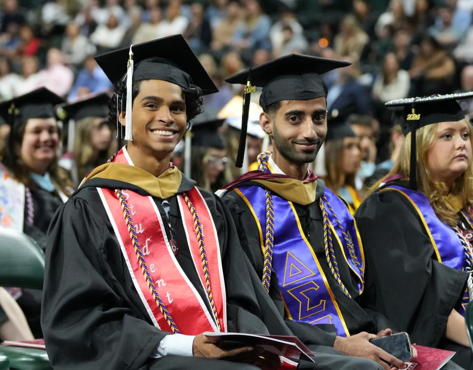 Graduating students sitting and smiling