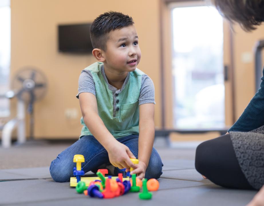 Child plays with toys with supervision