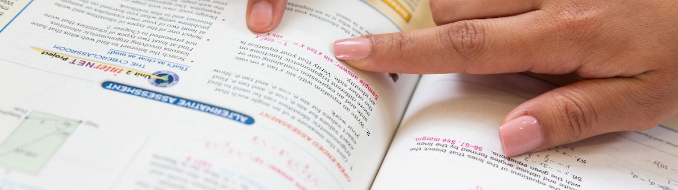 Students pointing in math textbook