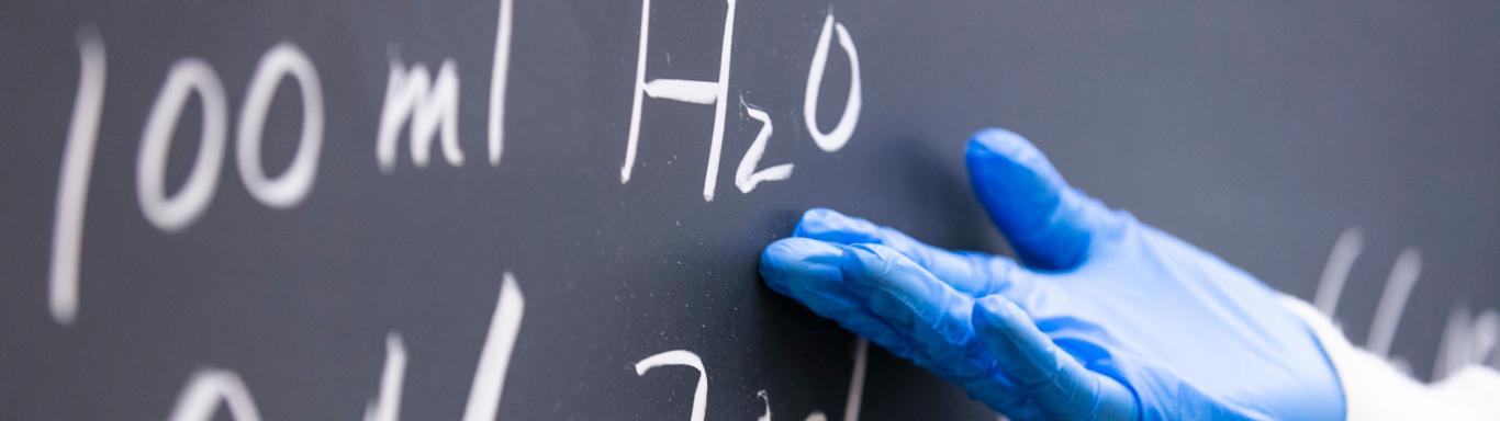 Person pointing to a chalkboard