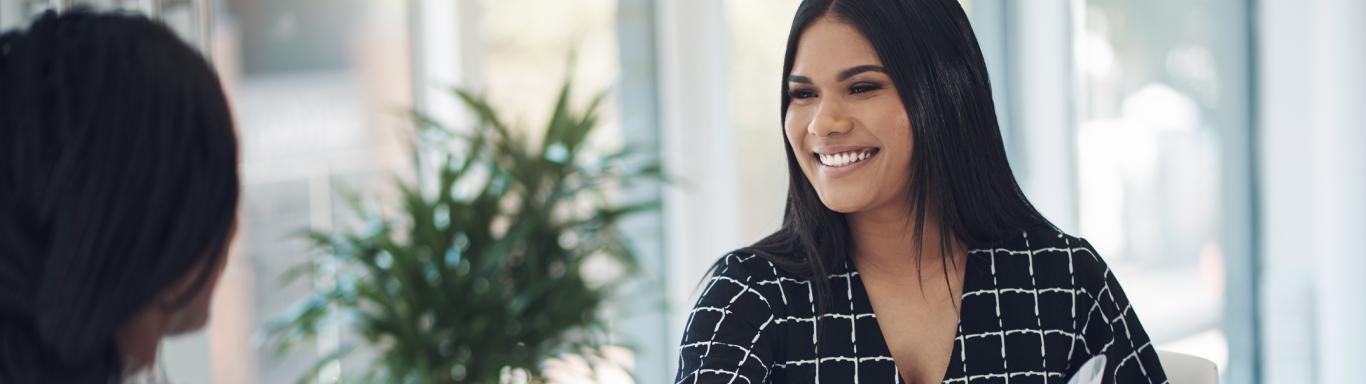 Two young businesswomen shaking hands in a modern office stock photo