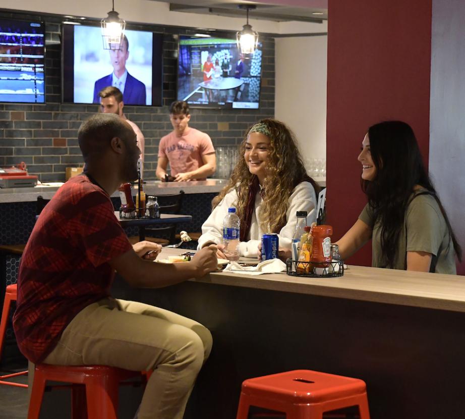 Students converse in Rider Pub