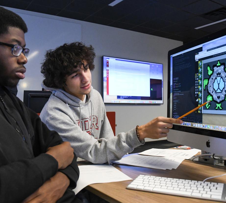 Two students work on video game on computer