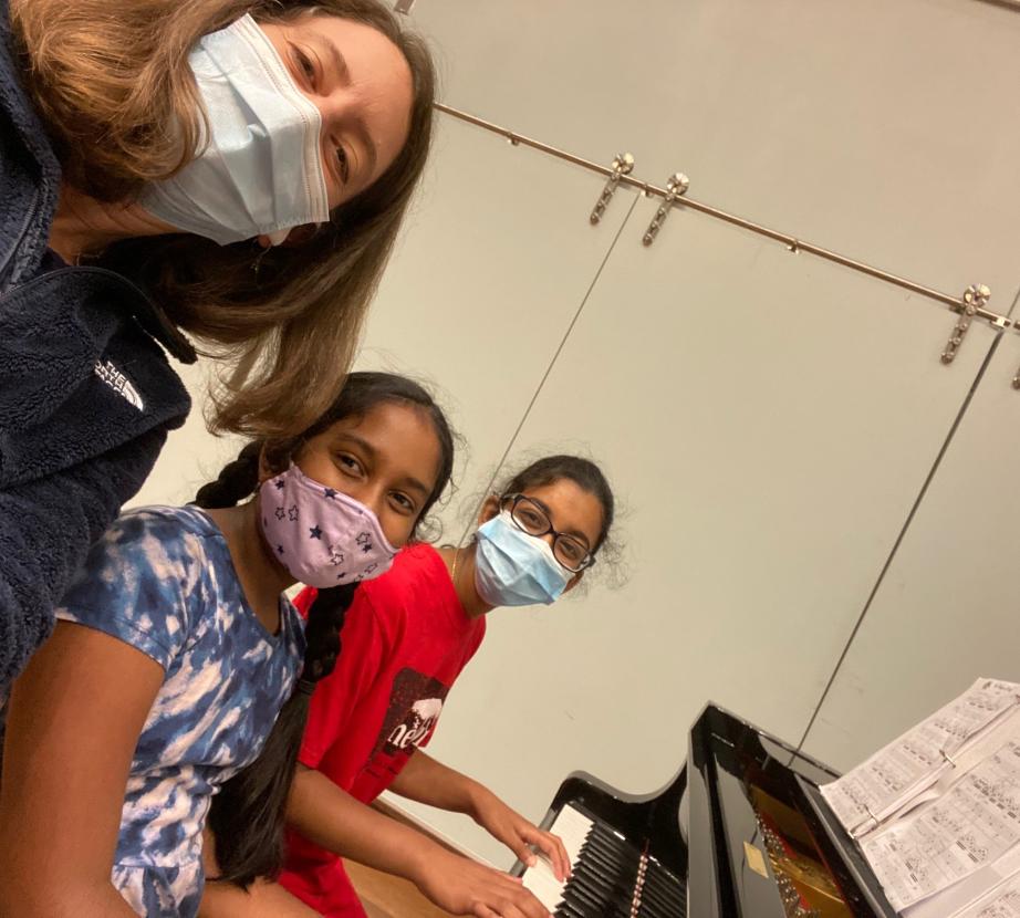 Two masked Piano Camp students with an instructor