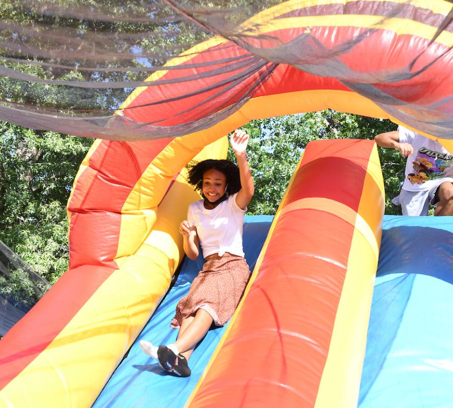 Student slides down inflatable slide