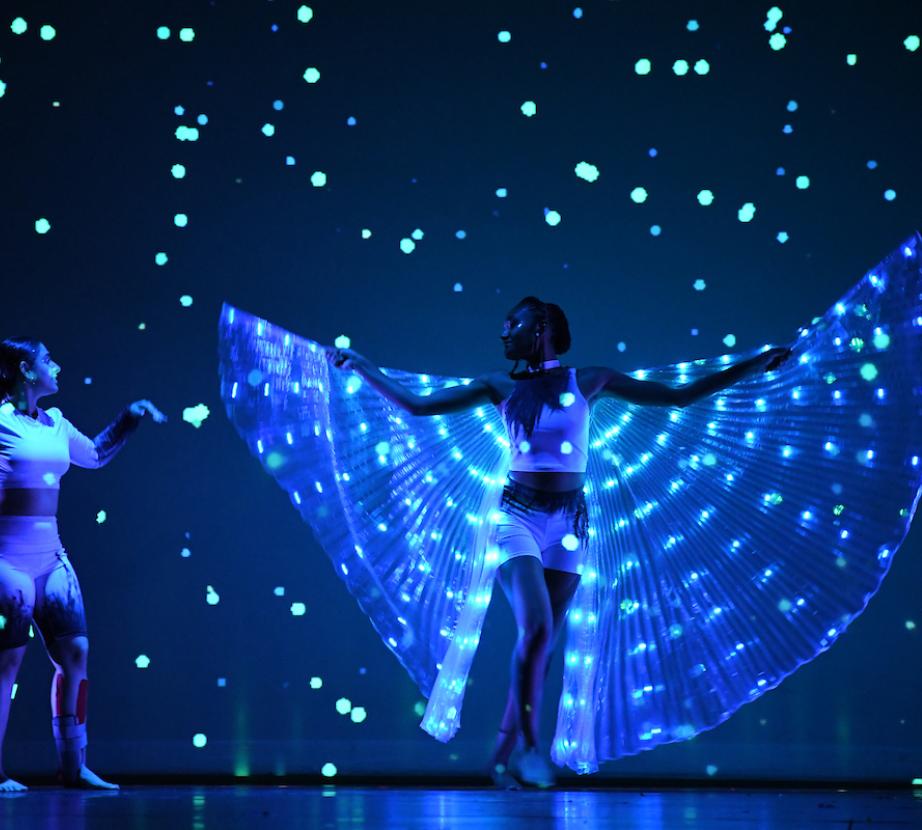 Two Rider students dance with dramatic lights