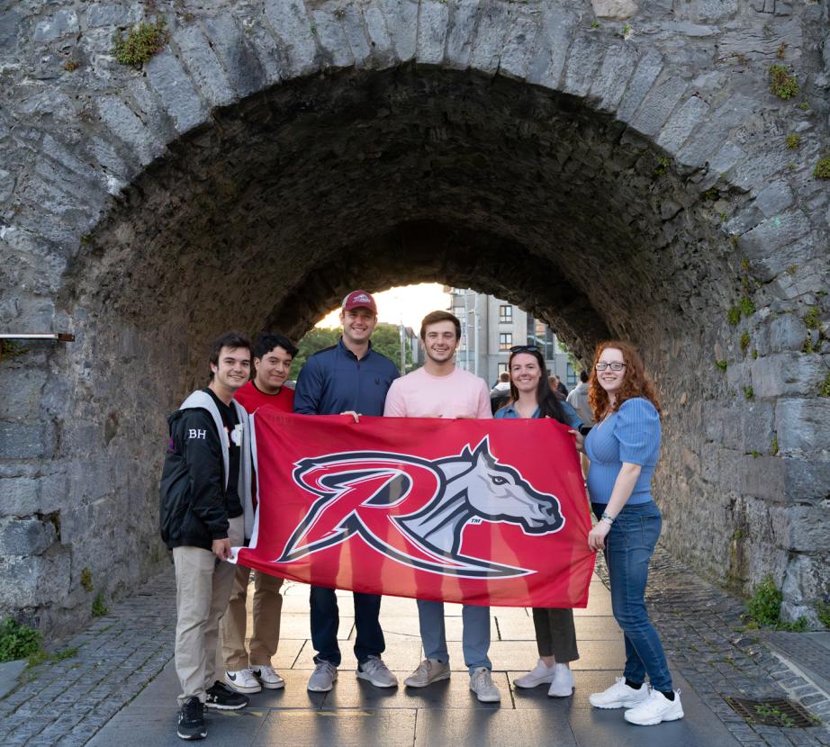 Study Abroad Business students with Rider flag 
