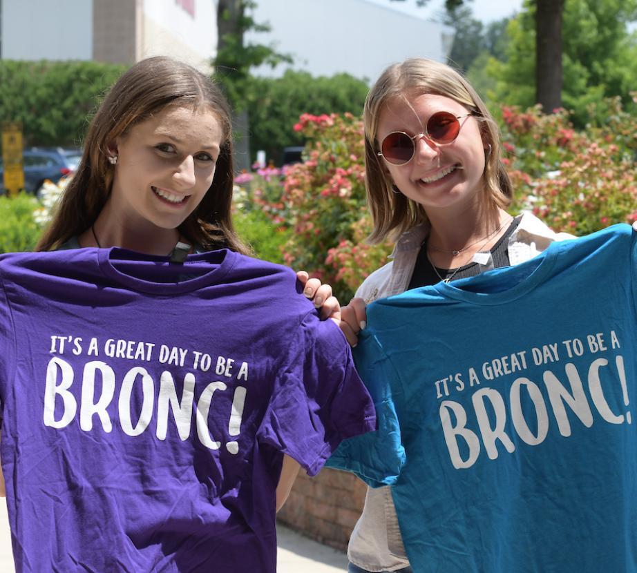 Students holding t-shirts