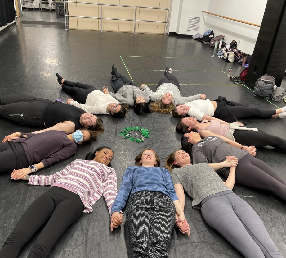 Students form a circle on the floor during dance/movement therapy class.