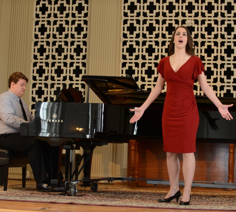 Woman sings on stage with piano