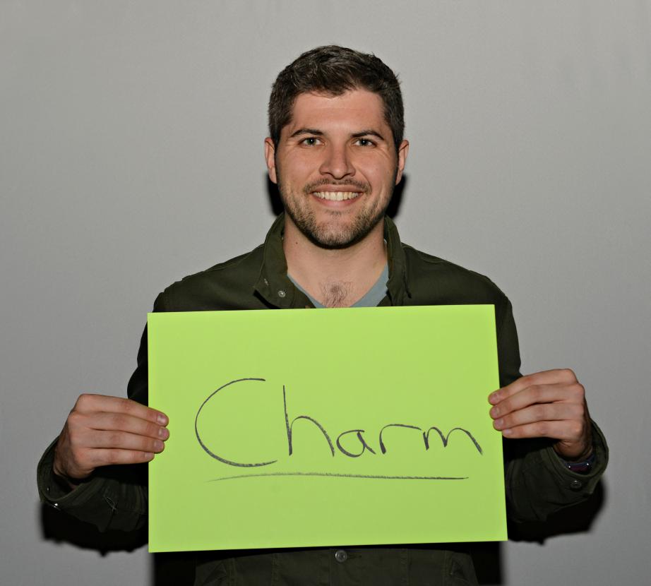 Man holding sign saying "Charm"