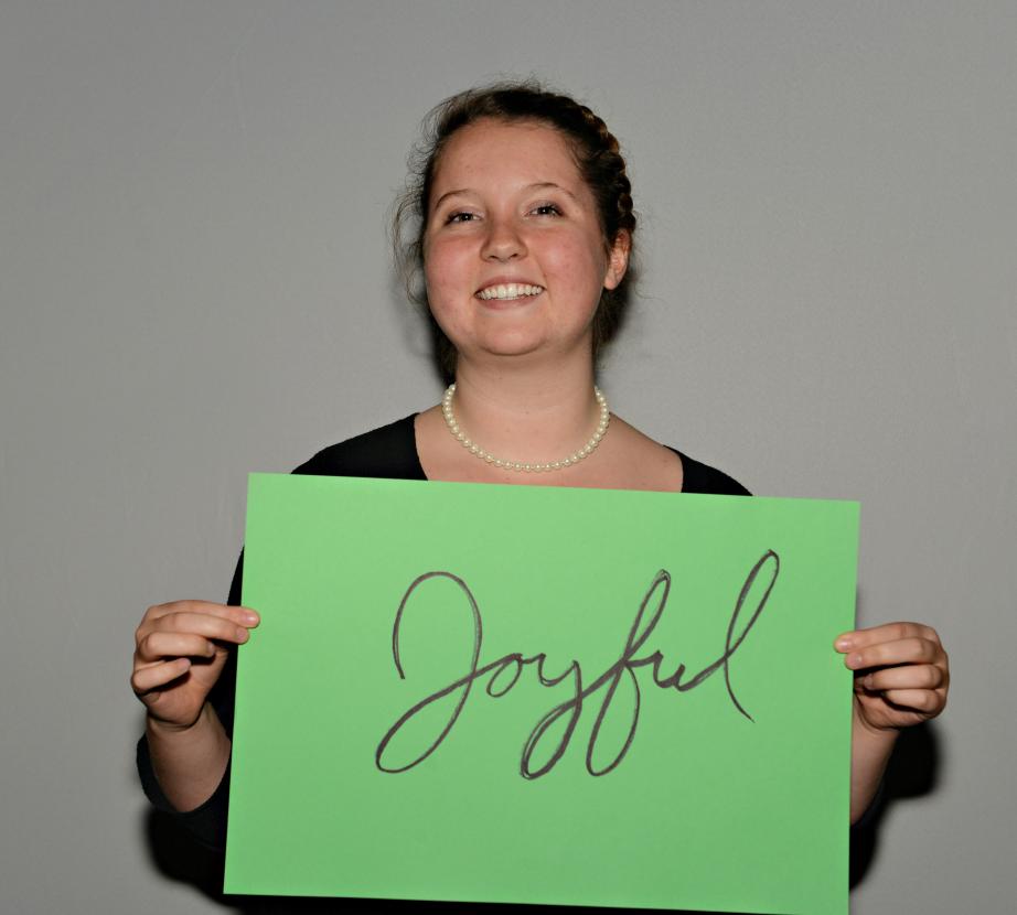 Woman holding sign saying "Joyful"