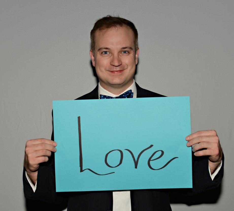 Man holding sign saying "Love"