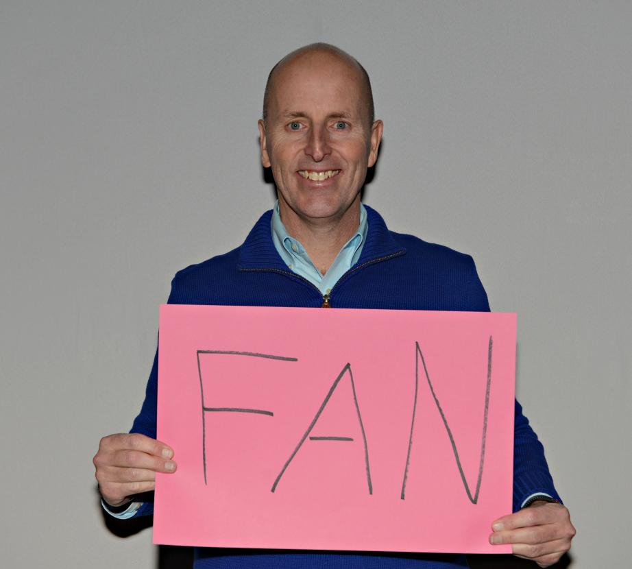 Man holding sign saying "Fan"