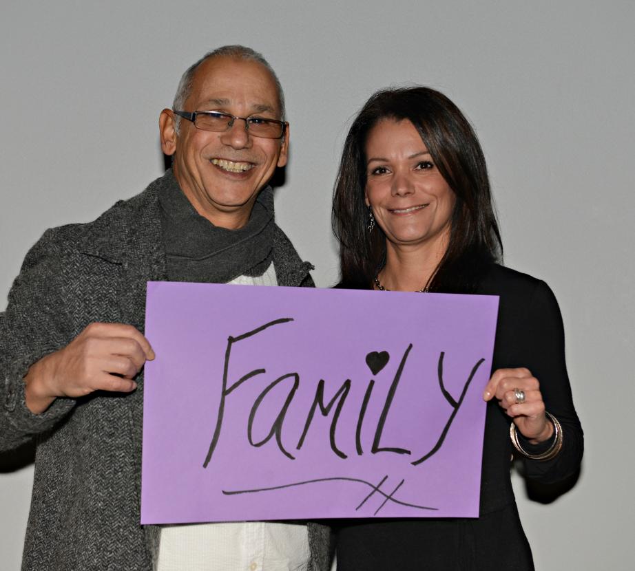 Man and woman holding sign saying "Family"
