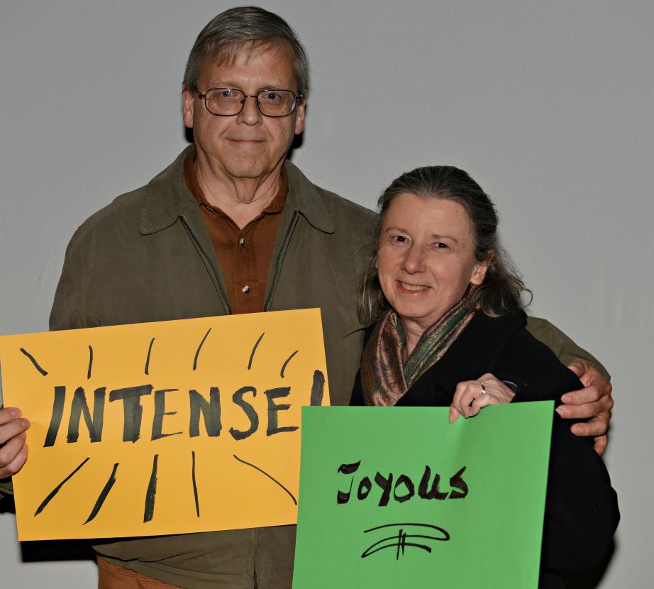 Man holding sign saying "Intense". Woman holding sign saying