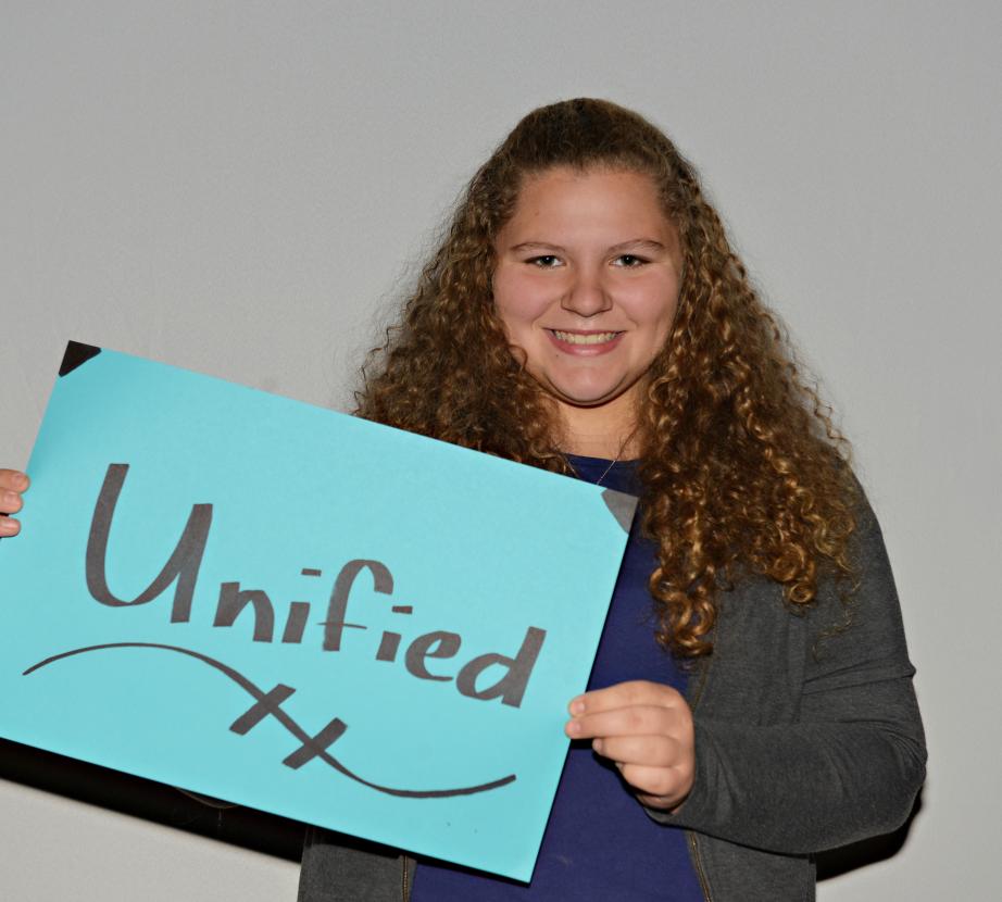 Woman holding sign saying "Unified"