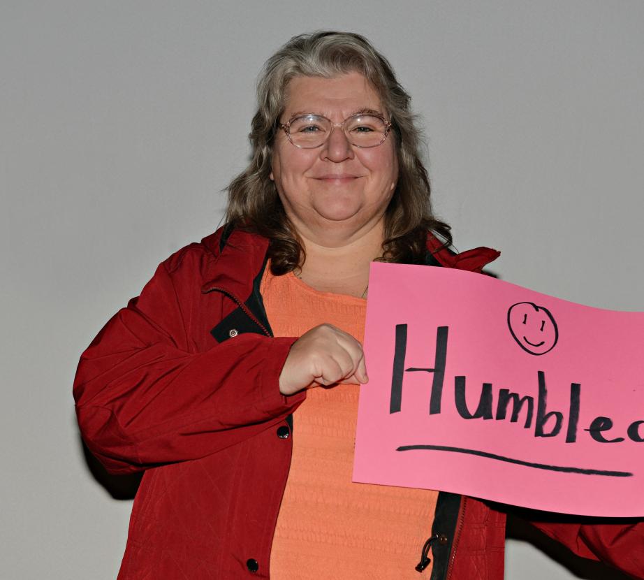 Woman holding sign saying "Humbled"