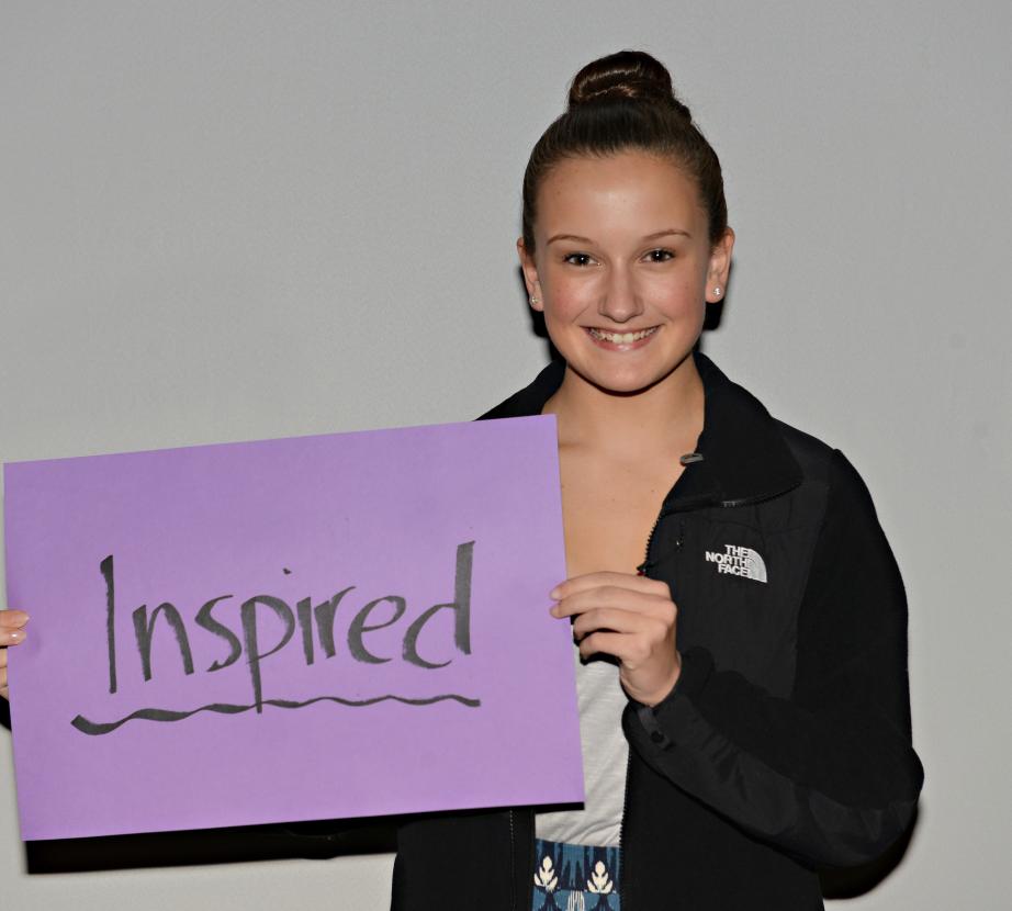 Girl holding sign saying "Inspired"